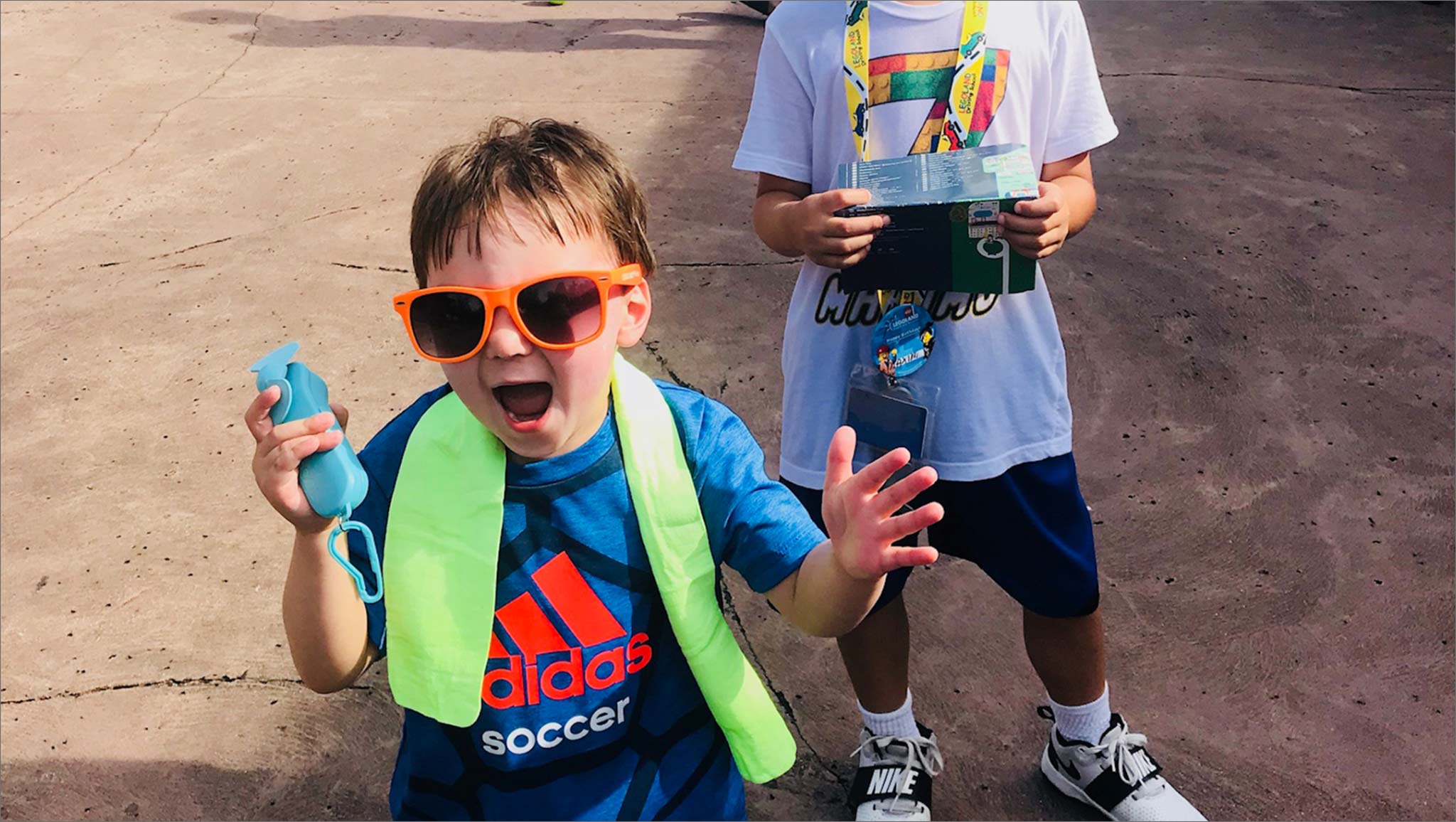 Marco walks outside laughing and wearing sunglasses with Maximo right behind him.