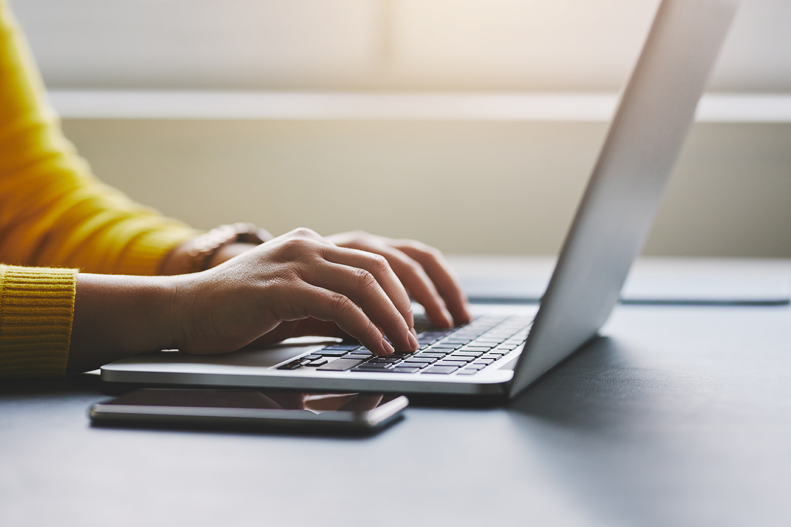 Close up of a woman's hands typing on a laptop computer. 