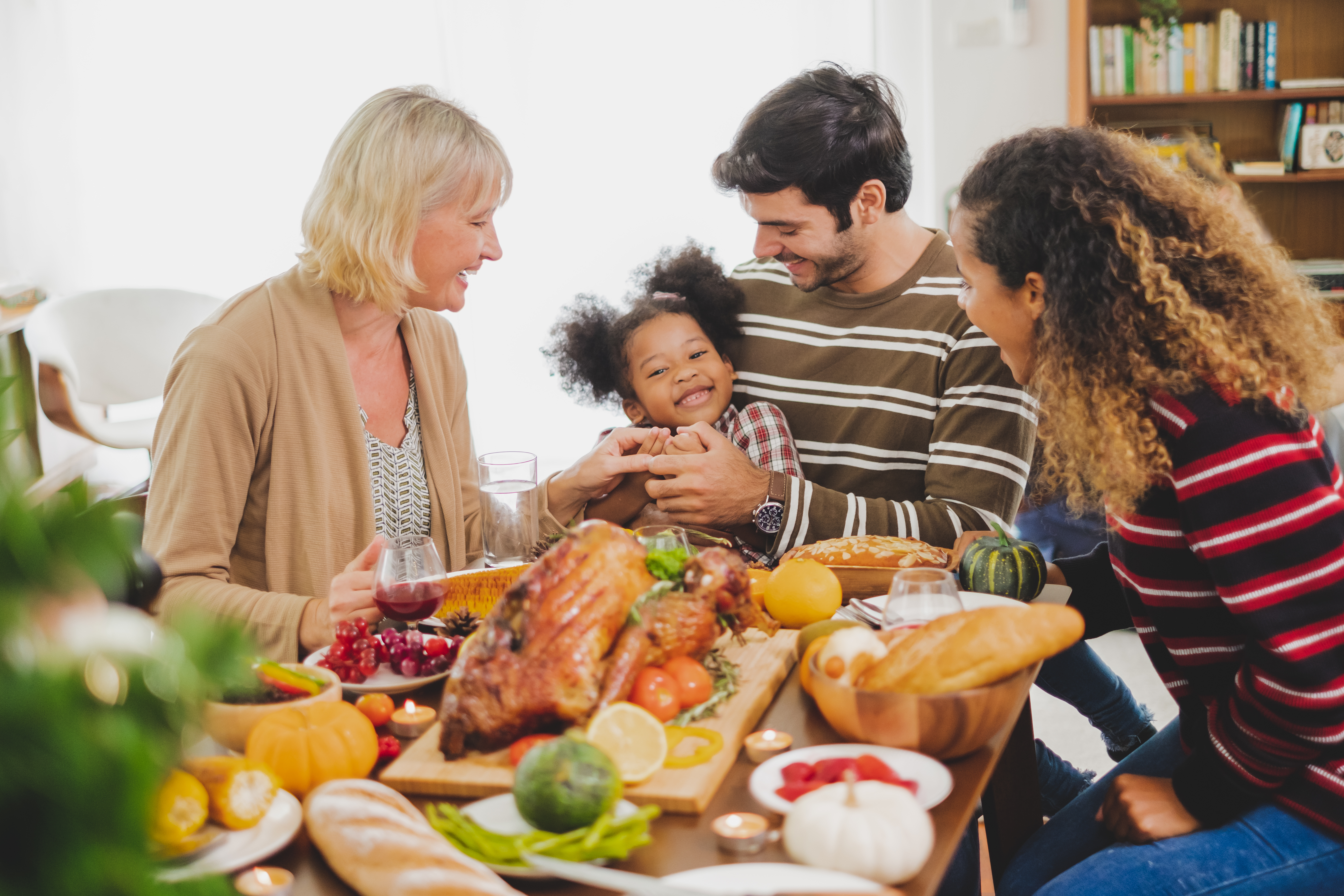 A family seated at a dining table for Thanksgiving.