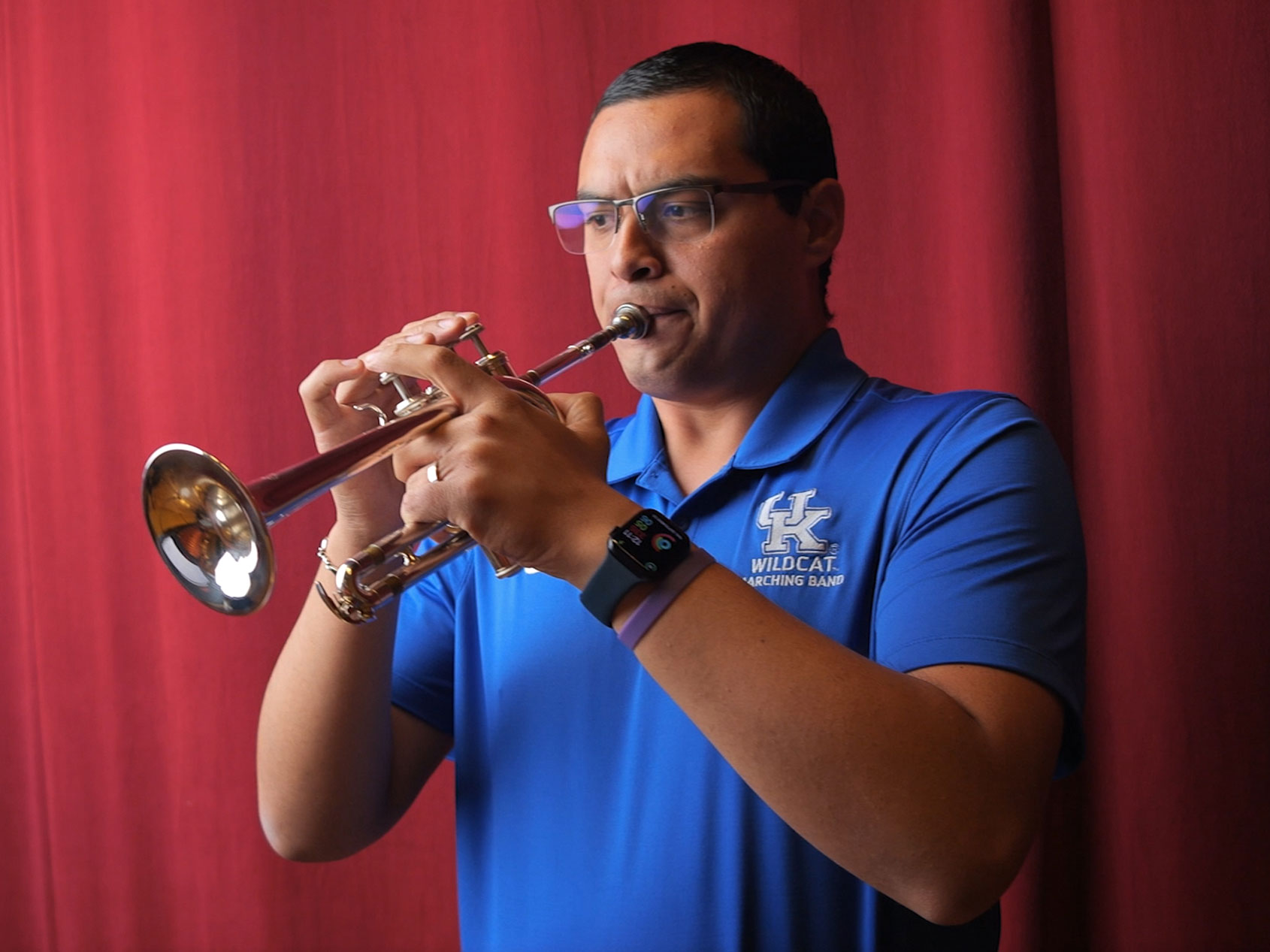 Adiel Nájera plays his trumpet onstage in an auditorium on the University of Kentucky campus.