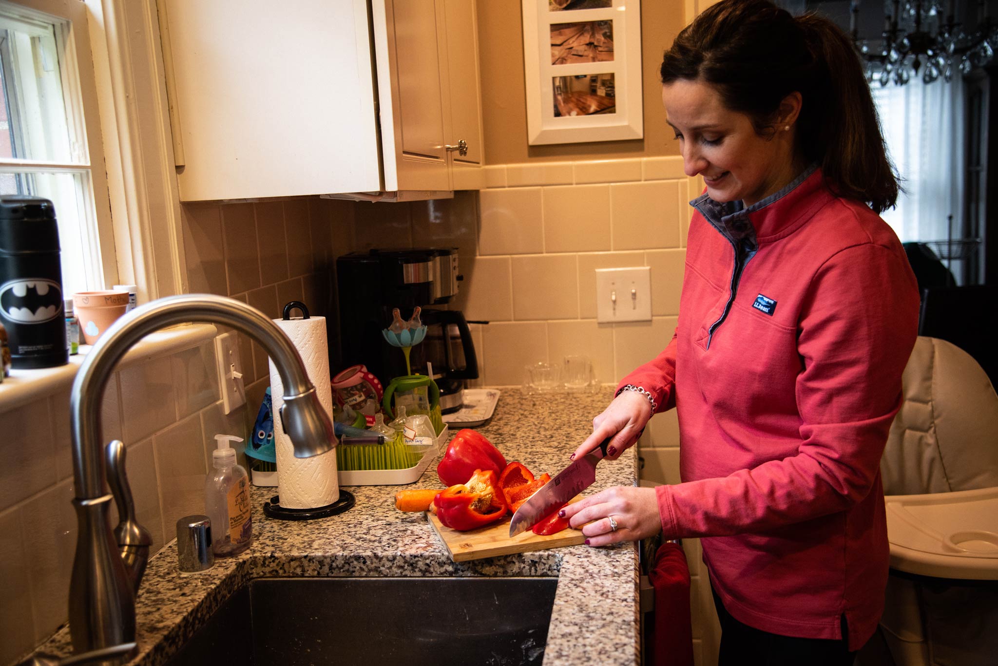Amberlee cuts up a red bell pepper in her kitchen.