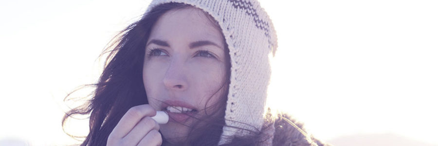 Woman uses lip balm.