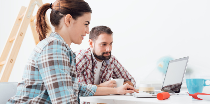 A couple looks at a laptop together.