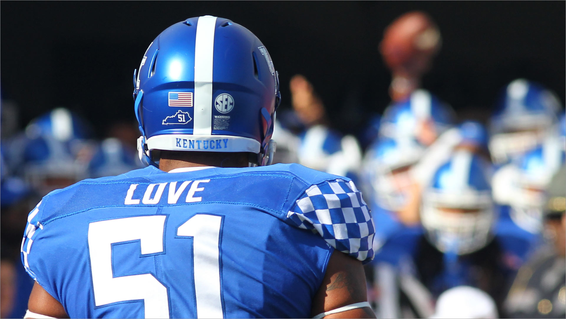 A close-up view of Courtney during his football days, wearing a jersey and helmet, viewed from behind.
