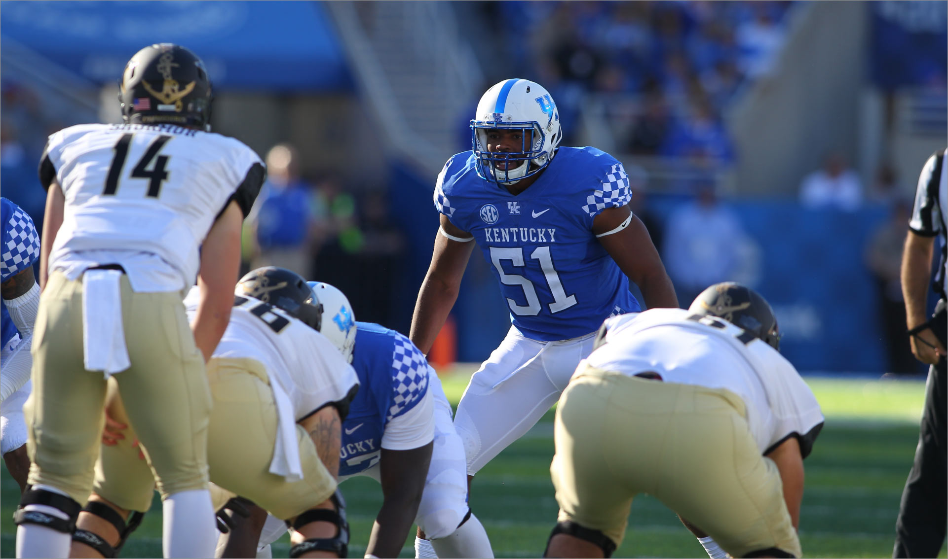 In a photo from his college football days, Courtney stands behind the line of scrimmage, wearing a blue Kentucky jersey with #51 on it.