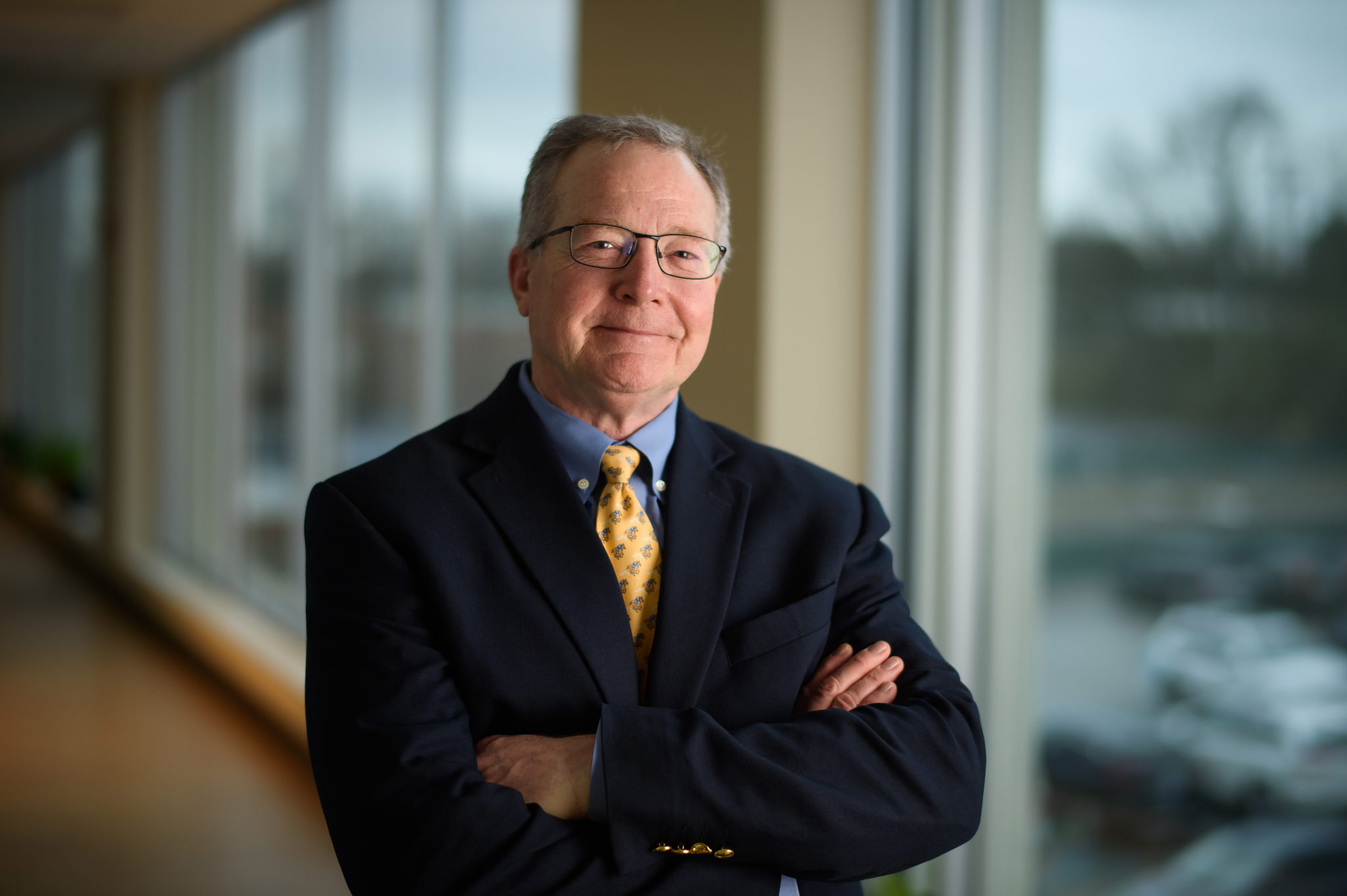 Dr. Mullett smiles with his arms crossed.