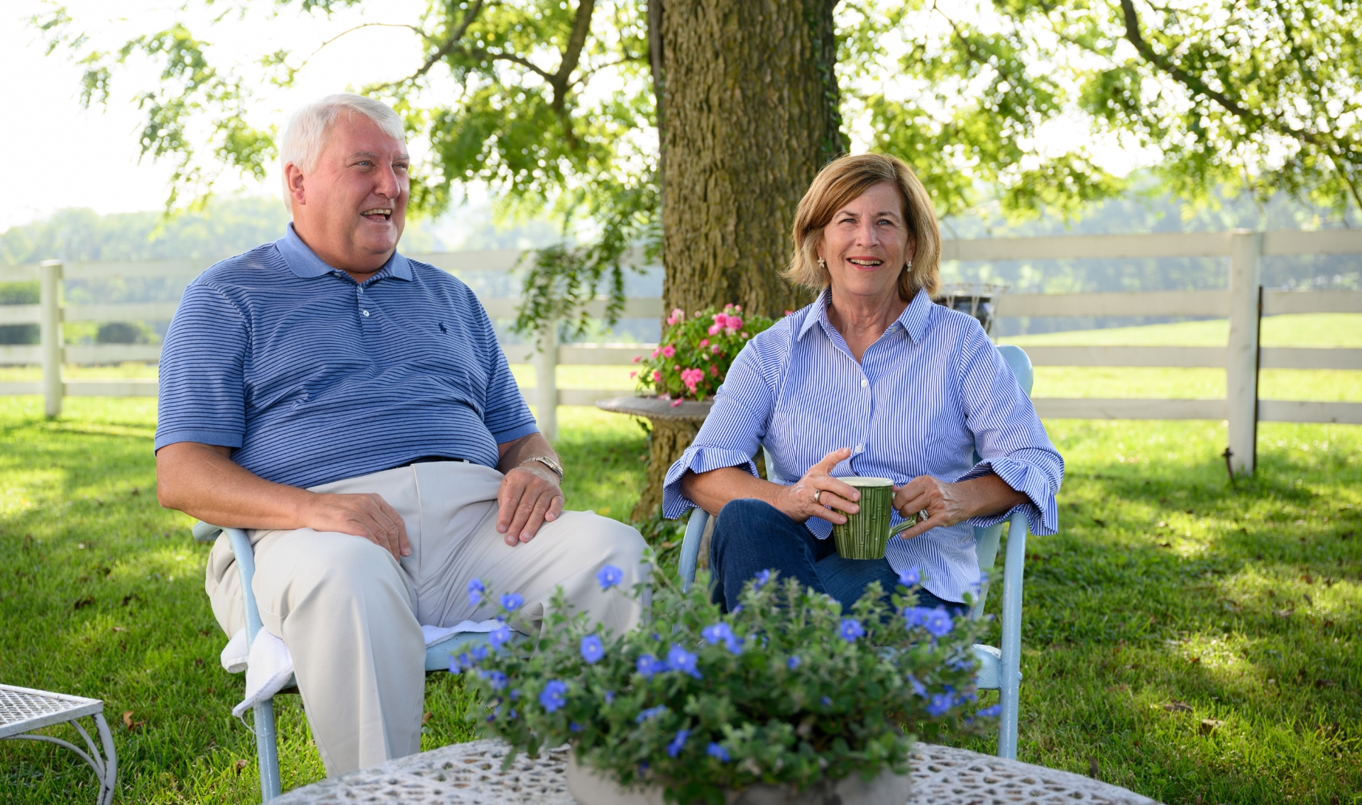 E and Cary sit in lawn chairs and laugh.