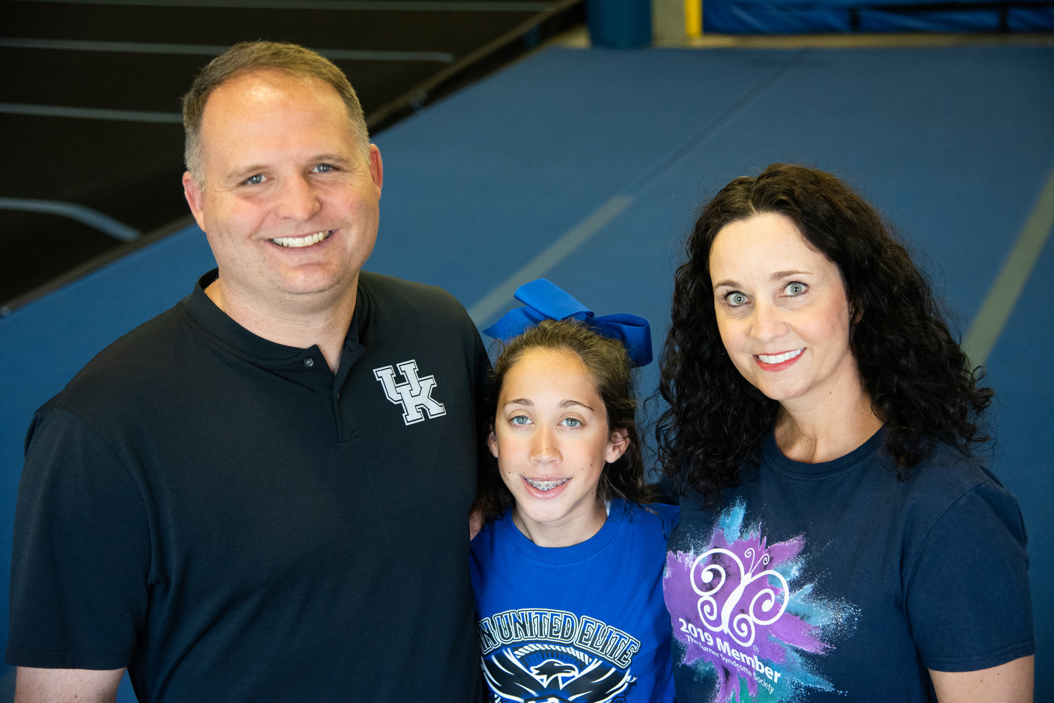 Gracie and her parents pose close-up to the camera while smiling