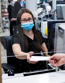 Retail pharmacy technician waits on customer