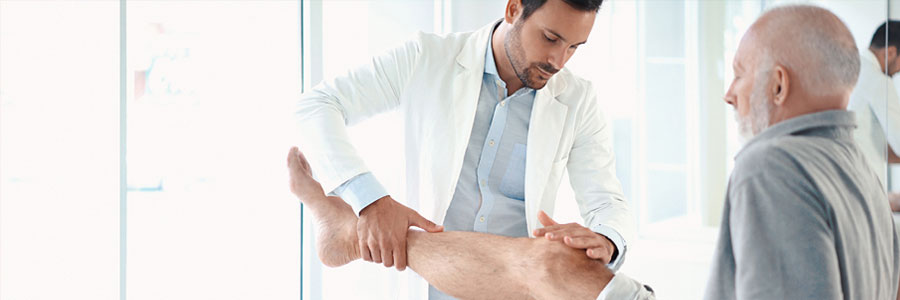 A doctor manipulates a patient's knee.