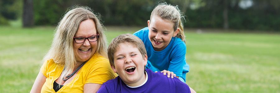 Mother and two children laughing in the park
