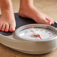 A woman's feet shown standing on a scale.