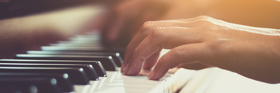 A pair of hands shown playing a piano.