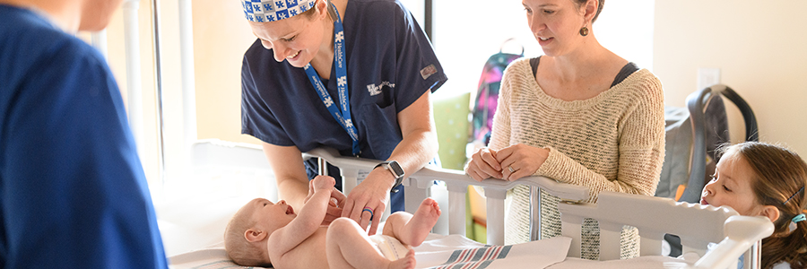 A surgeon from Kentucky Children's Hospital examines an infant with the patient's family in attendance.