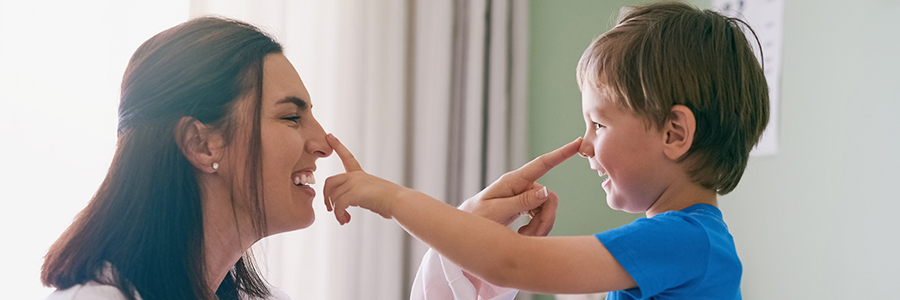 Doctor and child laughing while touching each other's noses