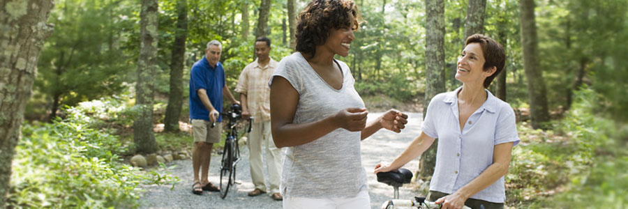 Two couples walking with bicycles