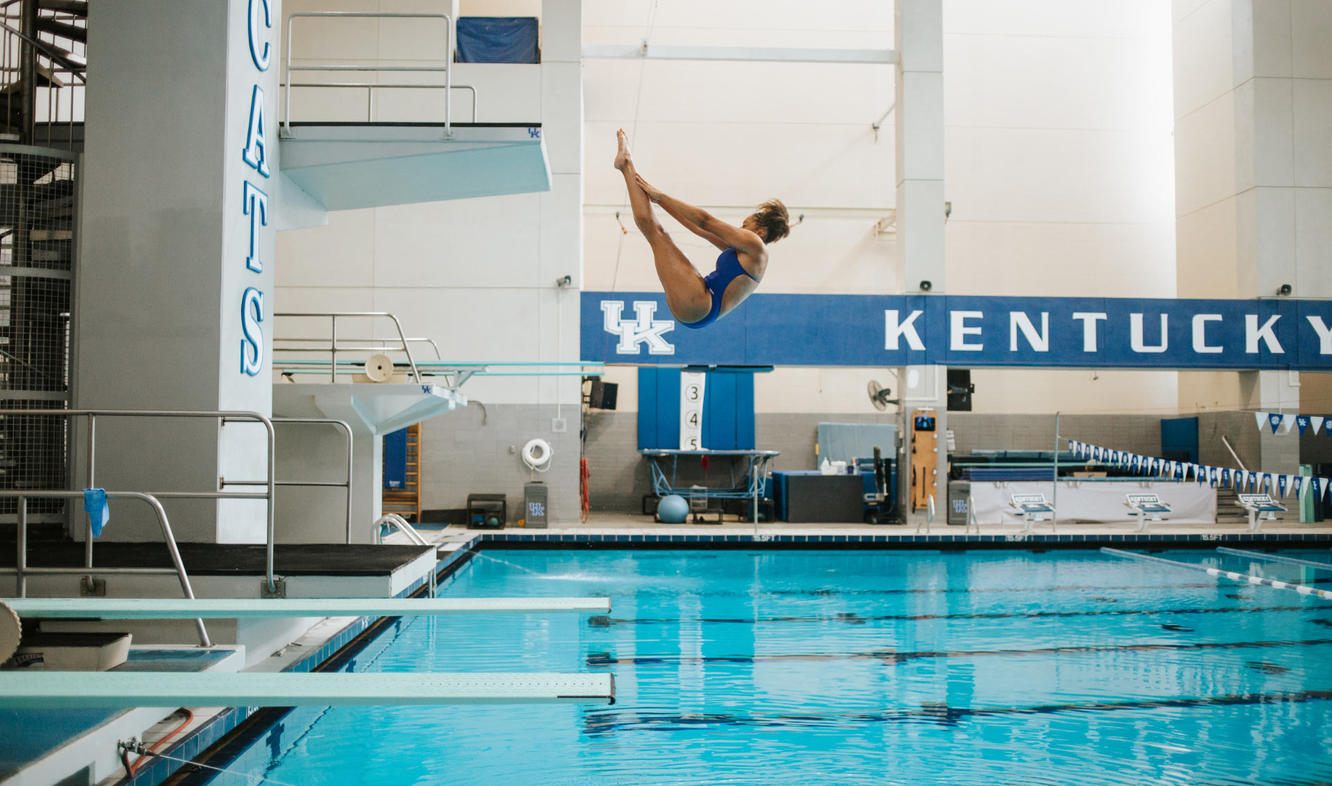 A photo of Jaida mid-dive, her body in the shape of a ‘V’ as she flips backwards into the pool.