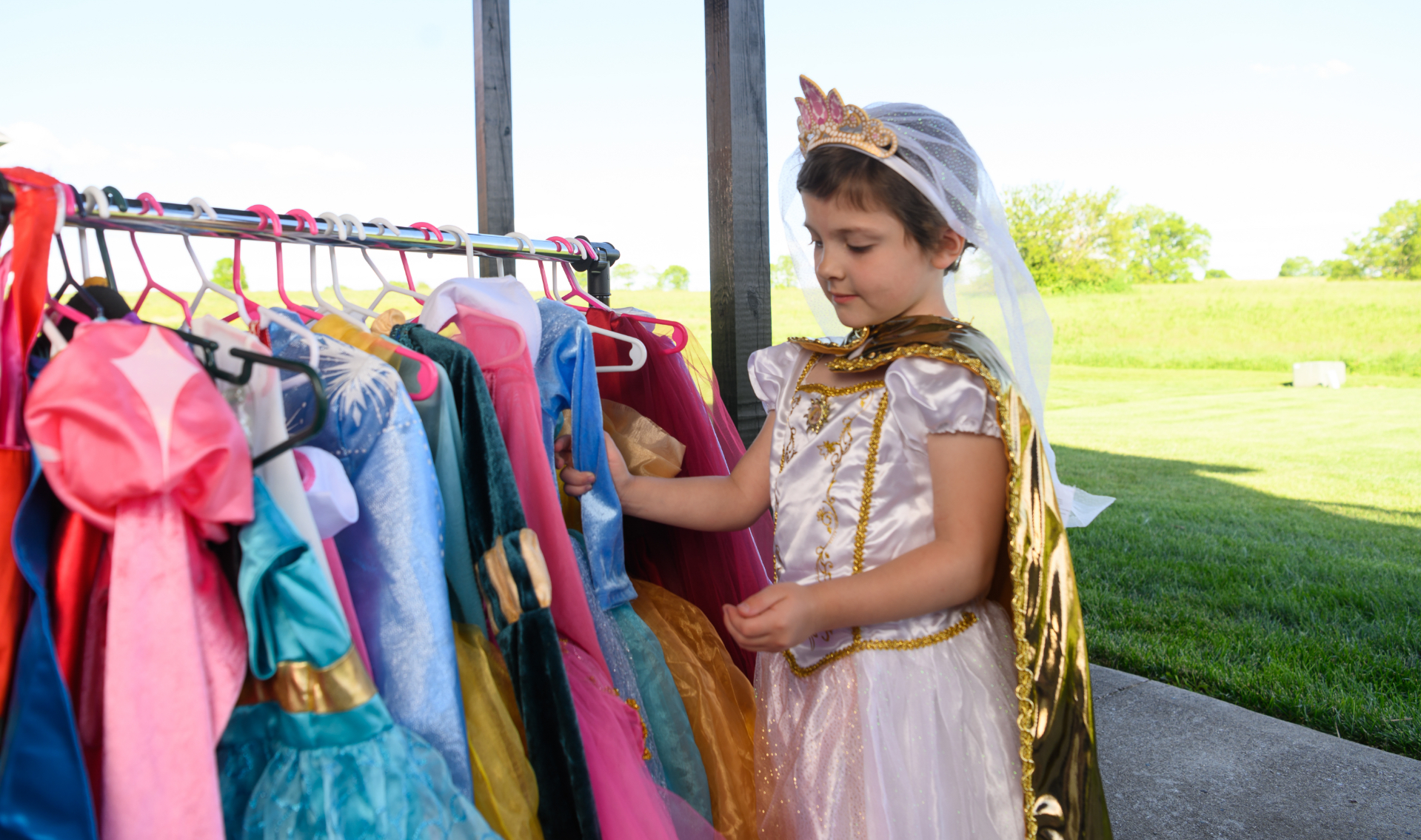 Leorah admires a rack of her costumes while wearing one herself.