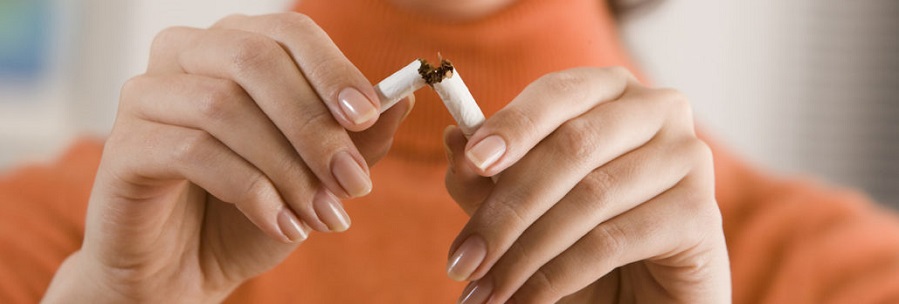 A woman breaking a cigarette in half.