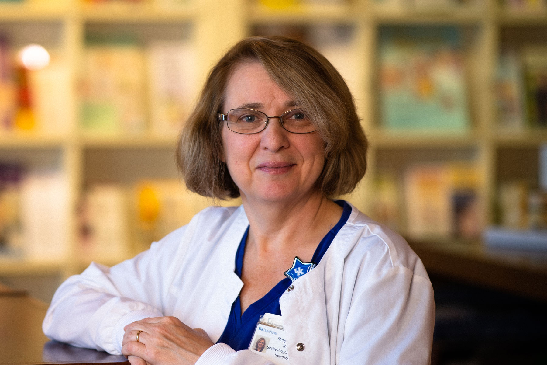 Margie leans against a shelf and smiles.