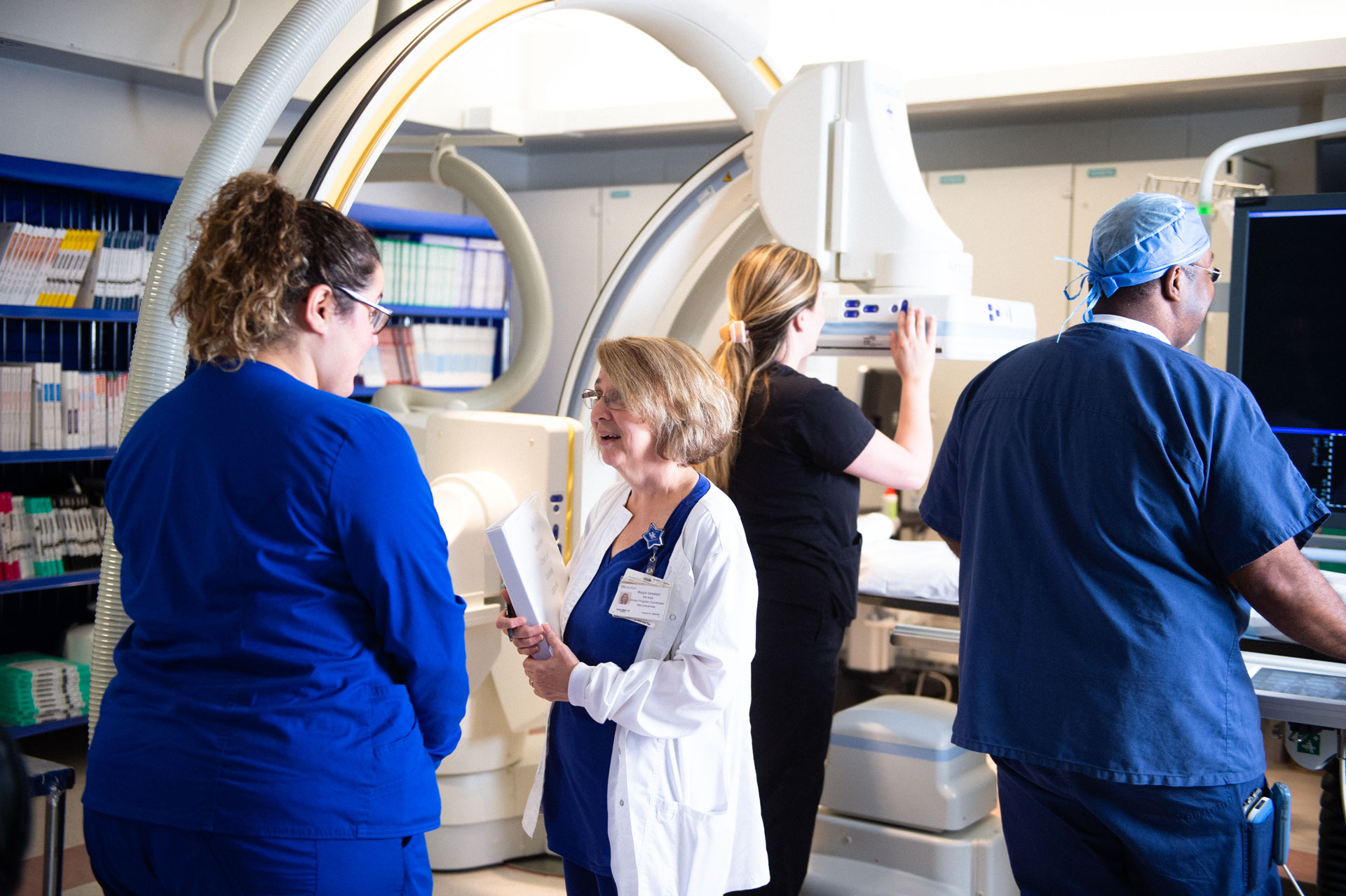 Margie talks with a nurse in a room with an x-ray machine behind them.