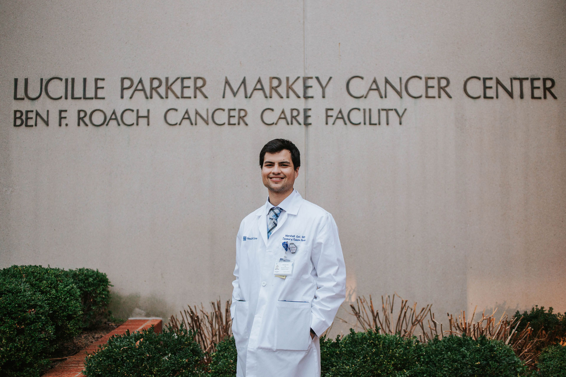 Marshall stands in front of the Lucille Parker Markey Cancer Center with his hands in his coat pocket, smiling broadly.