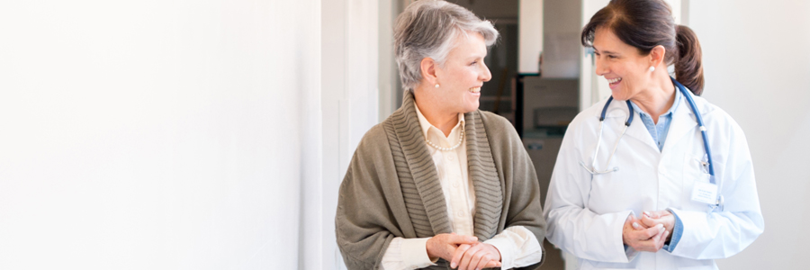 A mature woman talks with a female physician.