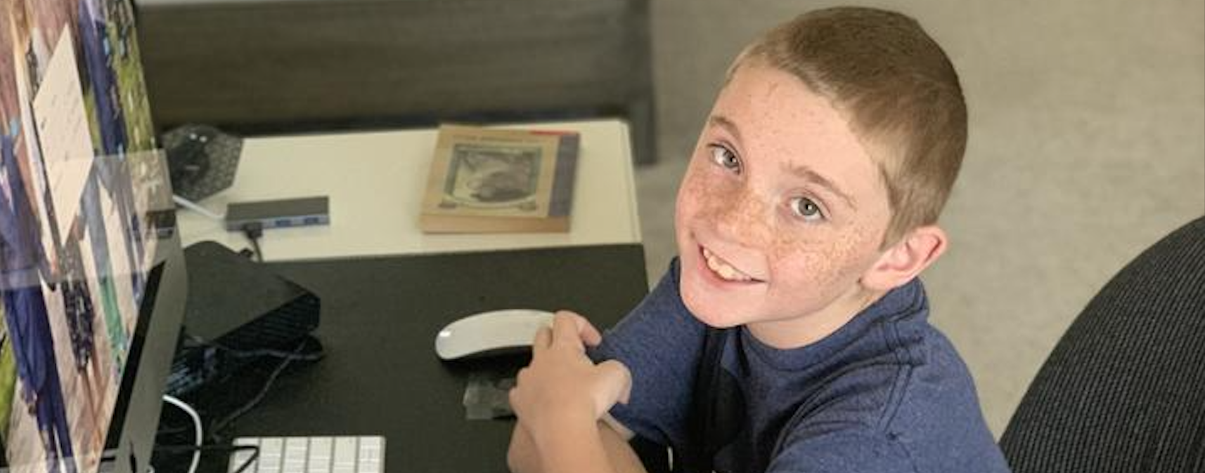 Max Coyne sitting at desk with computer.