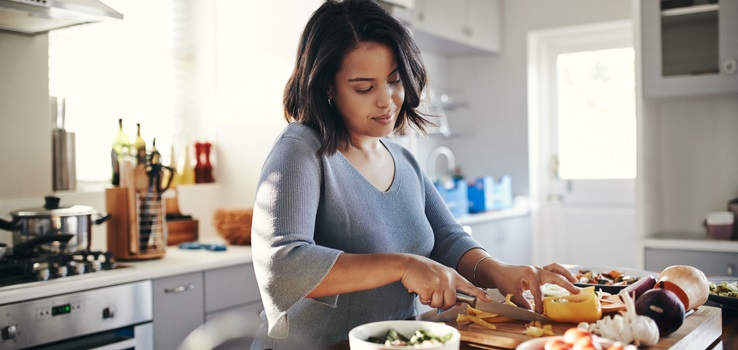 Woman chops vegetables for dinner.