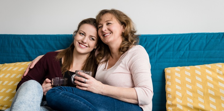 Mom and daughter sit on the couch.