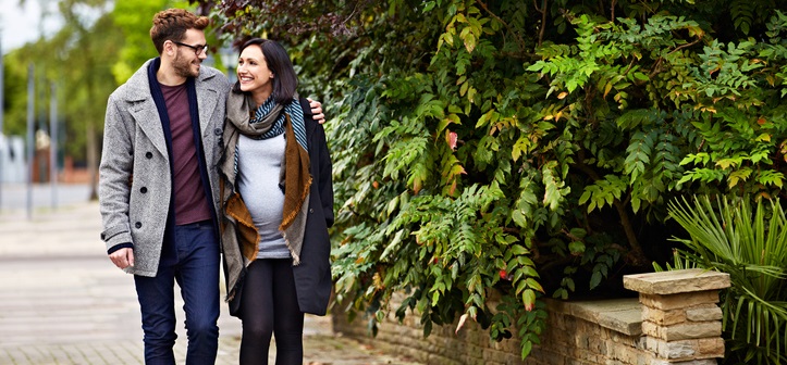 Pregnant woman walks with her husband.