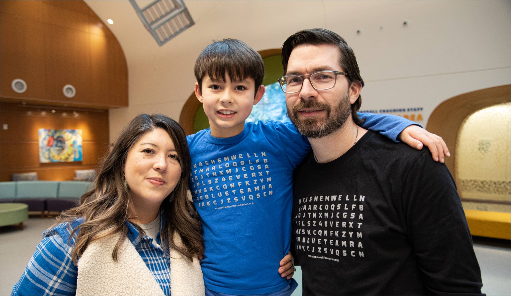 Liz, Maximo, and Benjamin pose for a family photo together.