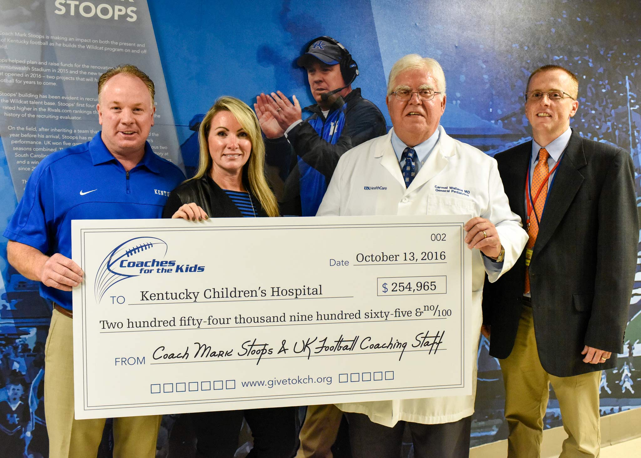 Mark and Chantel Stoops present an oversized check for $254,965 to two doctors from Kentucky Children’s Hospital.