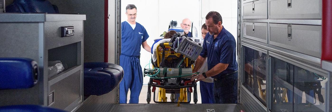 The ECMO team loads a patient into their vehicle.