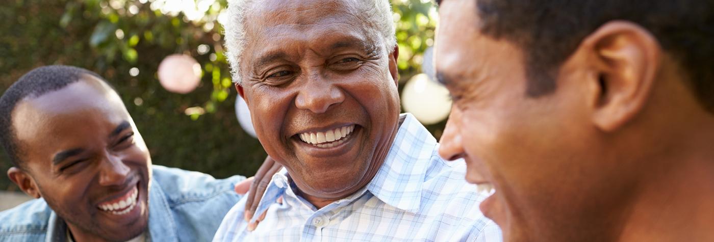 Close-up of three African-American men talking and laughing together.