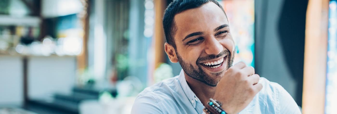 A man with a goatee smiles and laughs. 
