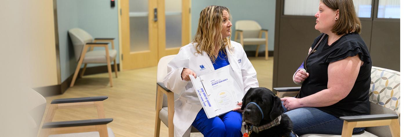 A member of the Weight Loss Surgery team reviews information in a binder with a patient.