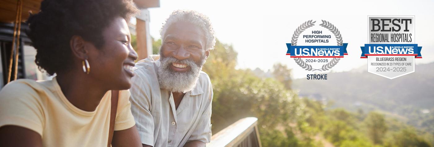 An African American man and woman smile at one another as they lean against a deck railing. Superimposed on the image are two badges: One reads, "US News & World Report High Performing Hospitals, 2024–2025, Stroke." The other reads, "US News & World Report Best Regional Hospitals, Bluegrass Region, Recognized in 23 Types of Care, 2024–2025."