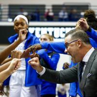 Coach Mitchell raises a fist with his players during a game and cheers with them.