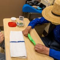 Levi Yoder works with putty as therapist Matthew Rose observes and directs.