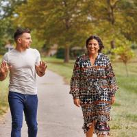 Nick Corman, left, and Jillian Kyde laugh while walking through a Lexington park.