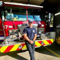 Nick Corman standing in front of a firetruck.