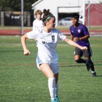Brooke Dawahare, center, runs up a soccer field.