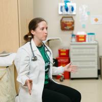 Dr. Katie Roberts, a sports medicine specialist, seated in a patient room.