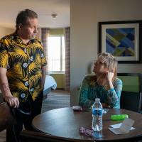 Ron Kelly, left and standing, looks at his partner, Deborah, seated, while they wait in a hotel room prior to an appointment.