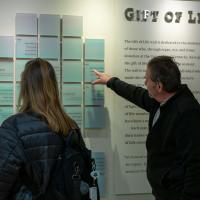 Ron Kelly, right, points to a donor message written on the Gift of Life wall at UK HealthCare. His partner Deborah, left, is also observing.