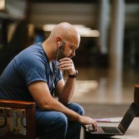 Aaron Harris sitting at a computer with headphones