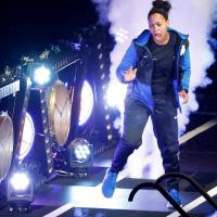 Amber, dressed in a black and blue sweatsuit, dances down a ramp of lights, clocks and fog machines at Big Blue Madness.