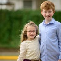 A photo of Cate and her brother posing together outside.