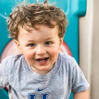 A portrait photo of Charlie, dressed in a gray UK t-shirt, smiling at the camera.